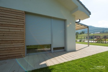 zatažené stříbrné venkovní rolety s podomítkovou schránkou u rodinného domku